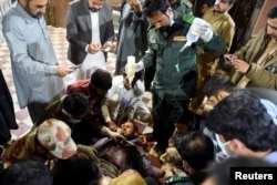 A passenger, who was rescued from a train after it was attacked by separatist militants receives medical aid at the railway station in Mach, Balochistan, on March 11.