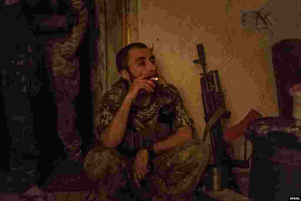 Avram pauses for a cigarette during a a firefight that has lasted for more than an hour. When he first arrived in eastern Ukraine, he was in a 12-man unit with just four rifles between them. &quot;Some of us only had knives, some found grenades, and we just fought however we could.&quot;