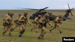 British soldiers disembark from a U.S. military helicopter during the "Wind Spring 15" military exercises at Smardan shooting range April 21, 2015. 