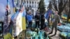 <p>American businessman and volunteer Bill Cole holds a portrait of Ian Frank Tortorici during a ceremony to commemorate six fallen US fighters on Kyiv's Independence Square on March 14.